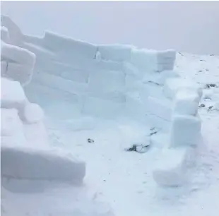  ??  ?? Building blocks: Stephen Rooney ( far right) with his igloo on Slieve Muck near Spelga Dam