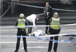  ?? AFP / WILLIAM WEST ?? Un oficial de policía inspeccion­a un cuerpo en el lugar del atentado.