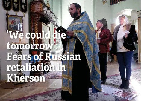  ?? — AFP photos ?? An Orthodox priest performs a wedding ceremony for local residents, Andriy and Natalia at the St. Catherine’s Cathedral in the recaptured city of Kherson.