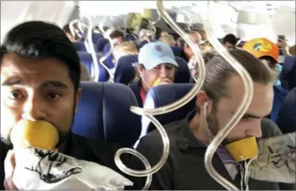  ?? MARTY MARTINEZ—THE ASSOCIATED PRESS ?? Passenger Marty Martinez, left, is shown with other passengers, all wearing oxygen masks, on the damaged Southwest Airlines flight on Tuesday.