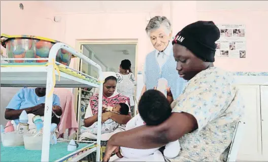  ?? ENRIQUE FIGUEREDO ?? Hora de comer. Sor Justina y unas monitoras atienden a los niños a la hora de biberón, que se guardan con su número en la nevera (foto abajo)