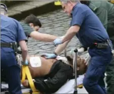  ?? STEFAN ROUSSEAU — PA VIA AP ?? An attacker is treated by emergency services outside the Houses of Parliament London, Wednesday. London police say they are treating a gun and knife incident at Britain’s Parliament “as a terrorist incident until we know otherwise.” The Metropolit­an...