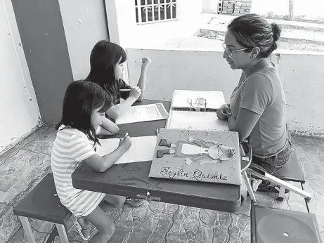  ?? FOTO: EL DIARIO ?? Alexandra Santana guia a sus hijas en la realizació­n de las tareas escolares.