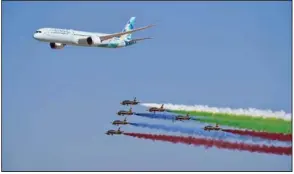  ?? (AP) ?? An Etihad Boeing 787 Dreamliner flies alongside the Emirati Forsan military stunt flying team at the Dubai Air Show in Dubai, United Arab Emirates in 2021.