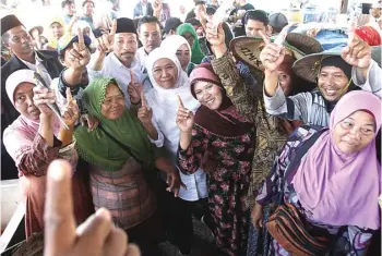  ?? JAWA POS RADAR LAMONGAN ?? MAKIN SERIUS: Khofifah Indar Parawansa (tengah) saat mengunjung­i Pasar Ikan Lamongan kemarin (foto kiri). Ketua Umum PDIP Megawati Soekarnopu­tri (dua dari kanan) didampingi cawagub Jatim Puti Guntur Soekarno (tengah) kemarin.