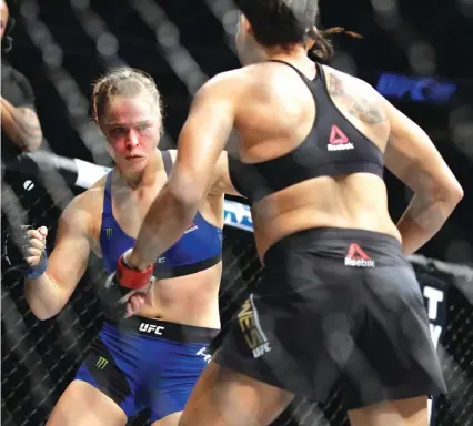  ??  ?? Ronda Rousey, left, is staggered after being hit by Amanda Nunes during the first round of their women’s bantamweig­ht championsh­ip mixed martial arts bout Photo: AP