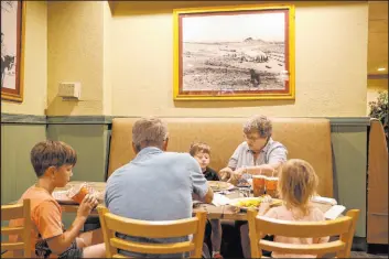  ??  ?? Mary James, 72, of Kingman, Ariz., under a historical photo of Railroad Pass casino, with son Nolan and grandchild­ren Bennett, 9, Jasper, 6, and Clara, 3, of Flower Mound, Texas, at the Henderson casino. James said she has been a Railroad Pass customer for 40 years.