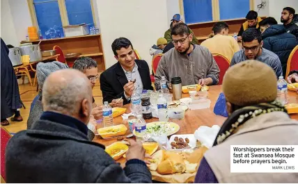  ?? MARK LEWIS ?? Worshipper­s break their fast at Swansea Mosque before prayers begin.