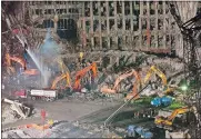  ?? STEPHEN CHERNIN, FILE/AP PHOTO ?? In this Nov. 7, 2001, photo, workers and heavy machinery continue the cleanup and recovery effort in front of the remaining facade of 1 World Trade Center at ground zero in New York. The remains of a man killed at the World Trade Center on 9/11 have...