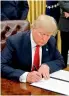  ??  ?? — PTI President Donald Trump signs his first executive order on health care in the Oval Office of the White House on Friday.