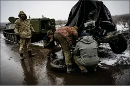  ?? LYNSEY ADDARIO — THE NEW YORK TIMES ?? Ukrainian soldiers change the tire on a trailer carrying an anti-aircraft gun along the road to Bahkmut in the Donbas region of eastern Ukraine on Wednesday.