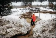  ?? GARY CORONADO/LOS ANGELES TIMES ?? CalTrans employee Christian Ochoa, 28, removes debris to allow water to flow into the Truckee River after heavy rains, ice dams and mud cause flooding along Highway 89 in the high Sierra Nevada on Jan. 8 near Floriston.