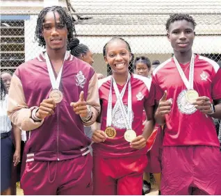  ?? ASHLEY ANGUIN ?? Muschett High’s double gold medallist Shanoya Douglas (centre) celebrates with gold medal winner Johan-Ramaldo Smythe (right) and bronze medal winner Osmond Holt during the recent parade to honour them by the school in Wakefield, Trelawny, after their success at the ISSA/GraceKenne­dy Boys and Girls’ Athletics Championsh­ips in March.