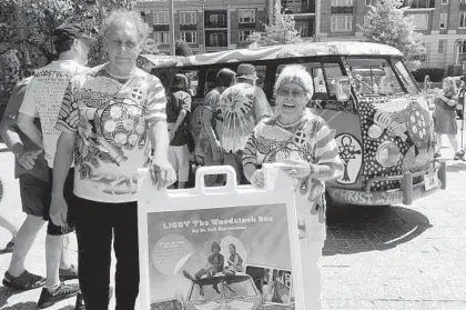  ?? AMY DAVIS/BALTIMORE SUN ?? Bob Grimm and Trudy Morgal, who traveled to Woodstock in the original VW hippie bus captured in the photo below them, stand outside AVAM with the new “Light” bus, heading to Bethel, NY, for the 50th anniversar­y of the Woodstock concert.