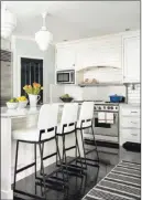  ??  ?? Although tiny pendant lights were once popular, designers now tend to choose more substantia­l overhead lighting above kitchen islands and select fixtures that can express the homeowners’ personal style.