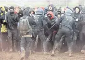  ?? OLIVER BERG AP ?? Police officers push back demonstrat­ors on the edge of the opencast lignite mine Garzweiler at the village Luetzerath near Erkelenz, Germany, on Saturday.