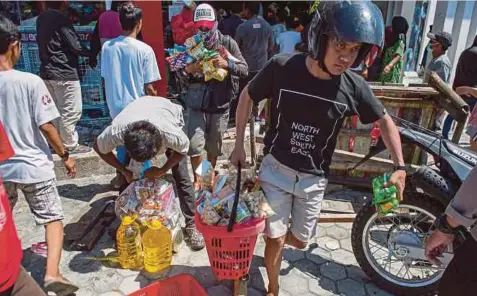  ?? Nasruddin ?? PENDUDUK memecah masuk sebuah pasar raya di tengah bandar untuk mengambil makanan, semalam. Ada antara penduduk terpaksa mencari sisa makanan di sebalik runtuhan kerana ketika ini sumber bahan mentah itu terhad”