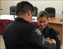  ??  ?? Troy police Sgt. Daniel Magnetto pins a sergeant’s badge to the uniform of his wife, new Sgt. Mary Kate Magnetto, during her promotion ceremony Monday morning in City Hall.