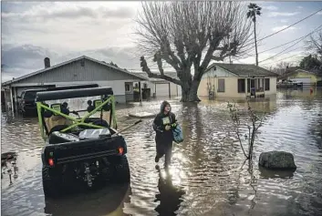  ?? Noah Berger Associated Press ?? BRENDA ORTEGA, 15, salvages items from her home in Merced this week. In California, only about 230,000 homes and other buildings have f lood insurance policies, which are separate from homeowners insurance.