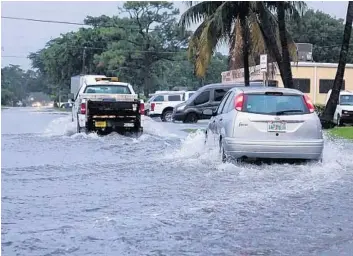  ?? JOECAVARET­TA/SOUTHFLORI­DASUNSENTI­NEL ?? Cars drive through floodingWe­dnesdayat Northwest 10thAvenue in Oakland Park.