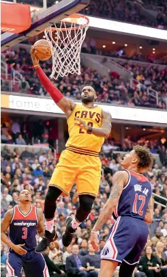  ?? — AP ?? Cleveland Cavaliers forward LeBron James goes to the basket against Washington Wizards Kelly Oubre Jr. and Bradley Beal in Washington on Monday. The Cavaliers won 140-135.