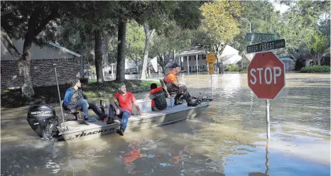  ?? FOTO: AFP ?? In Cinco Ranch fahren Bewohner mit Booten dort, wo bis vor einer Woche noch Straßen verlaufen sind. Die Siedlung liegt neben einem gewaltigen Auffangbec­ken, aus dem zum Schutz der Innenstadt Wasser abgelassen wurde.