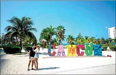  ?? ?? A couple takes a selfie at a beach in Cancun.