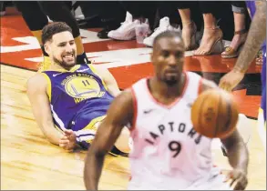  ?? Carlos Avila Gonzalez / The Chronicle ?? Golden State Warriors’ Klay Thompson grimmaces after falling to the floor injured after coming down from a jump shot early in the fourth quarter during Game 2 of the NBA Finals against the Toronto Raptors at Scotiabank Arena on Sunday in Toronto.