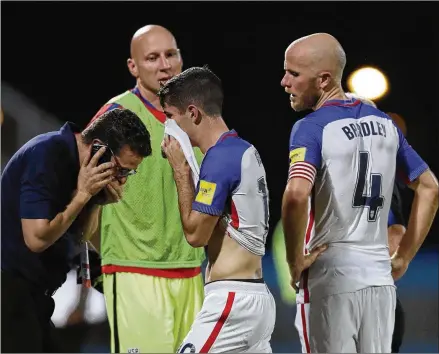  ?? REBECCA BLACKWELL / ASSOCIATED PRESS ?? Christian Pulisic (center) and U.S. teammate Michael Bradley show their dejection Tuesday after losing 2-1 at Trinidad and Tobago and failing to qualify for the 2018 World Cup. Atlanta United goalie Brad Guzan (in the background) did not play.