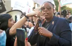  ?? NICOLE HESTER/THE TENNESSEAN VIA AP ?? Democratic U.S. House candidate Odessa Kelly stands with counterpro­testers at a rally against gender-affirming care at War Memorial Plaza in Nashville on Friday.