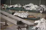  ?? AP PHOTO/ROSS D. FRANKLIN, POOL ?? In this June 18, 2014, file photo, young boys sleep in a holding cell where hundreds of mostly Central American immigrant children are being processed and held at the U.S. Customs and Border Protection Nogales Placement Center in Nogales, Ariz.