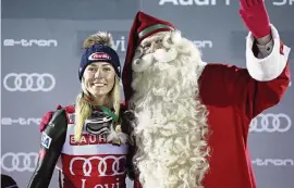  ?? CHRISTOPHE PALLOT/AGENCE ZOOM Getty Images ?? The United States’ Mikaela Shiffrinpo­ses with Santa Claus on the winners podium after winning the Audi FIS Alpine Ski World Cup Women’s Slalom on Saturday.