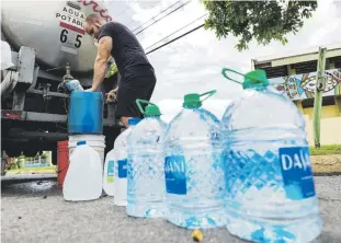  ?? ?? En la foto, Kevin Albarrán, vecino de Loíza, se abastecía de agua de un camión ubicado en la carretera 187.