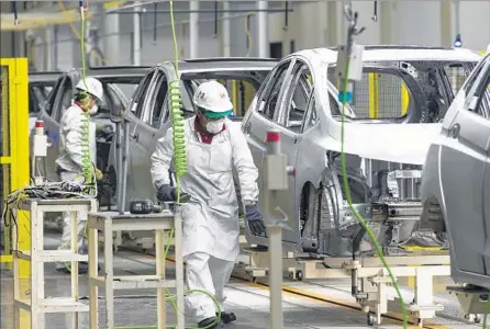  ?? Omar Torres AFP/Getty Images ?? MANY PEOPLE ACROSS the political spectrum believe that the North American Free Trade Agreement needs to be revised and updated. Above, automobile­s make their way down the assembly line of a Honda Motors factory in Celaya, Mexico, in 2014.