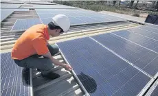  ??  ?? A Gunkul technician works on a solar rooftop installati­on.
