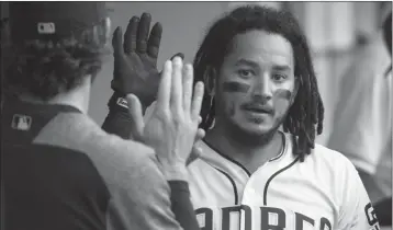  ?? ASSOCIATED PRESS ?? SAN DIEGO PADRES’ FREDDY GALVIS is welcomed in the dugout after scoring during the third inning of a Saturday’s game against the New York Mets in San Diego.
