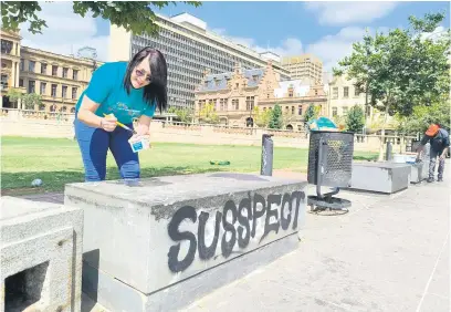 ?? Picture: Marizka Coetzer ?? CLEAN-UP. A woman helps remove grafitti at Church Square in Pretoria.