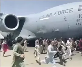  ?? Associated Press ?? HUNDREDS OF PEOPLE run alongside a U.S. Air Force C-17 as the transport plane moved down a runway at the airport in Kabul, the Afghan capital, in August.