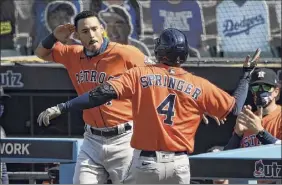  ?? Kevork Djansezian / Getty Images ?? George Springer of the Astros celebrates his two-run homer with Carlos Correa in the third inning of Game 2. Springer also homered in the fifth.