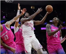  ?? MATT SLOCUM — THE ASSOCIATED PRESS ?? The 76ers’ Joel Embiid, center, goes up for a shot against the Wizards’ Kyle Kuzma, from left, Daniel Gafford and Delon Wright during the second half on Sunday in Philadelph­ia.