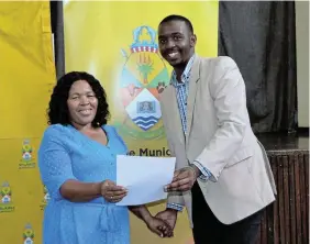  ?? ?? BIG DREAMS: Anele Lwalweni, a third-year student at University of Limpopo, receives his letter confirming his registrati­on funding from Ndlambe mayor Khululwa Ncamiso.