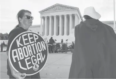  ?? J. SCOTT APPLEWHITE/AP ?? People demonstrat­e in front of the Supreme Court in Washington during the first day of the new term on Oct. 4.