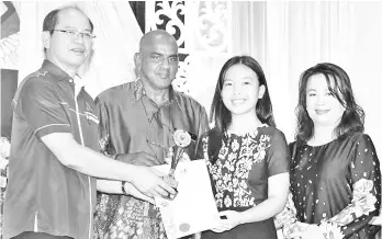  ??  ?? One of SMK Tamparuli’s high achievers receiving the award from Tangau.