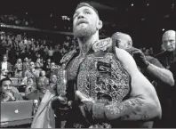  ?? AP PHOTO ?? In this Nov. 13, 2016, file photo, Conor McGregor leaves the octagon with his title belts after knocking out Eddie Alvarez during a lightweigh­t mixed martial arts bout at UFC 205 at Madison Square Garden in New York.