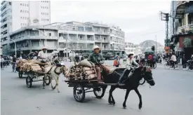  ??  ?? Donkey-drawn carts take wood supplies to old Phnom Penh Getty
