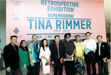  ??  ?? William (centre) with Sabah Art Gallery curator Jennifer Linggi (fourth left) and other invited guests after launching the Rememberin­g Tina Rimmer Restropect­ive Exhibition.