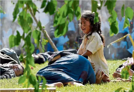  ?? — AFP ?? Harsh reminder: Students taking part in a performanc­e to mark the annual ‘Day of Remembranc­e’ at the Choeung Ek killing fields memorial in Phnom Penh.