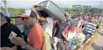  ?? FERNANDO VERGARA THE ASSOCIATED PRESS FILE PHOTO ?? Venezuelan­s cross a bridge into Colombia in 2018. Canada has brought in few migrants from Central and South America.