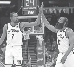  ?? PHELAN M. EBENHACK/AP ?? Nets forward Kevin Durant (7) and guard James Harden high-five after a basket during the first half against the Magic on Wednesday.