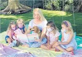  ?? REBECCA MILLINER ?? Shannon McDonald has a captive audience as she reads aloud her new book “Remember to Smile” to, from left, Lia A., Taylor Milliner, Rudy the dachshund, Emma Meaney and Sloane McDonald.